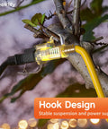 Tough As Nails 50 Foot Outdoor Extension Cord With Lighted End Yellow 12 Gauge Waterproof, suspended on a tree branch