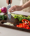 Top Shelf Solid Walnut End Grain Cutting Board Heavy Duty Kitchen Prep Surface With Deep Juice Channels 17X13X1 Inch, with chopped vegetables.