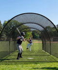 Baseball player hitting in 33 Ft Batting Cage With Frame For Baseball Softball And Golf Backyard Practice Cage For Yard Or Field Heavy Duty Polyester Netting With Fiberglass Poles 1.25 Inch Mesh Fully Enclosed Training Space on a field