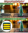 3D Christmas Tree Soldering Kit With LED Flashing Lights In 7 Colors, showing USB and battery power options on a table