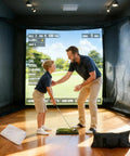 Father coaching son in front of 10x8 Ft Golf Practice Net With Impact Screen And Mat Beefy Steel Frame for indoor golf training.