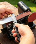 Person using Hella Versatile Mini Belt Sander And Four In One Compact Grinder With Polishing Wheel And Sanding Disc for knife sharpening.