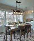 Industrial Farmhouse 5-Light Kitchen Island Pendant In Wood And Metal Dope Linear Chandelier With Antique Gold And Black Finish Ideal For Dining Room Or Kitchen Sloped Ceiling Compatible Easy Install And Adjustable Chain hanging over dining table in modern kitchen setting.