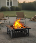 32 Inch Fire Pit Table Outdoor Patio Heater Square Metal Stove For Backyard And Garden with fire burning, chairs around