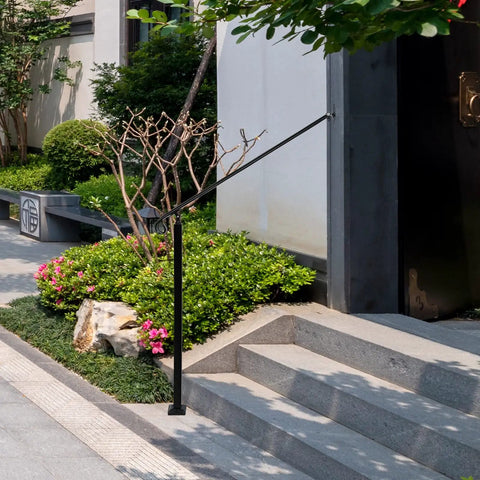 Heavy Duty Adjustable Stair Handrail Rock Solid Wall And Floor Mounted Wrought Iron Safety Rail Built Tough For One To Three Steps No Sweat Installation In Matte Black Steel on outdoor steps with lush landscaping.