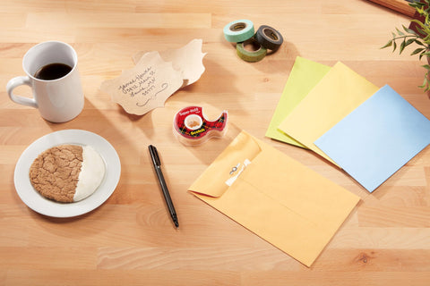 Super Hold Tape With 50 Percent More Adhesive, Clear Finish, 2 Rolls on desk with envelopes and coffee mug