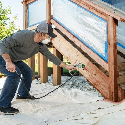 Man using Heavy Duty Mobile Airless Paint And Stain Sprayer Cart for smooth finishes on wooden steps.
