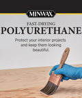 Pro Grade Protective Polyurethane Spray With Slick Clear Warm Gloss And Badass Tough Oil Formula For Interior Woodwork Furniture Cabinets And Floors Fast Drying Aerosol being applied with a brush on wood.