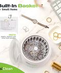 Ultrasonic Retainer Cleaner with built-in basket for jewelry and small items, surrounded by jewelry pieces on a marble surface.