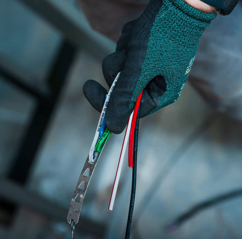 Gloved hand holding Heavy Duty Building Wire Stranded Copper 12 Gauge 1 Conductor 20 Amp 600 Volt 90 Degree Celsius PVC Jacket 500 Foot Black
