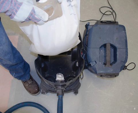 Person inserting VB140F 5 Pack 14 Gallon White Fleece Filter Bags For Dust Extractor VAC140 into vacuum for dust filtration