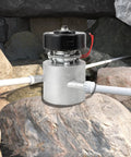 Three-Phase AC Hydro Generator With Three Inlet Portable Water Turbine on a rock in a natural setting.