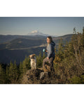 Woman hiking with dog holding Hike Kit Essentials for outdoor adventures.