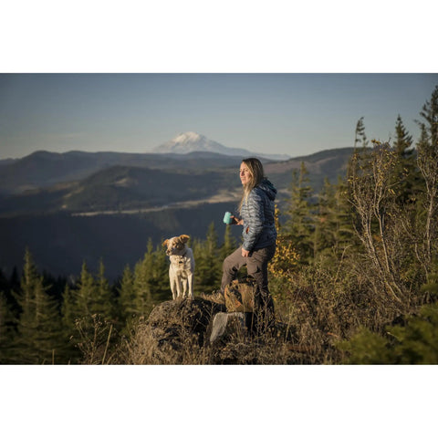Woman hiking with dog holding Hike Kit Essentials for outdoor adventures.