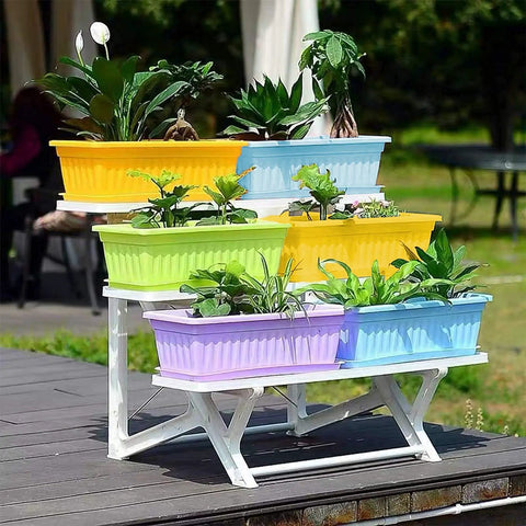 Four Pack Rectangular Window Flower Box Planters With Trays For Balcony Windowsill Garden Durable Eco Friendly Plastic Great For Flowers Herbs And Small Vegetables 16.8 Inch Long, displayed on a balcony with plants