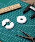 White circular wall cable grommets set (4 pcs) with split inserts for cable routing; top-down view on cutting mat.