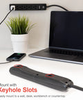 Six Outlet Power Strip With 6 Ft Extension Cord 4 Pack Heavy Duty Flat Plug Grounded Built In Circuit Breaker 3 Prong Wall Mount UL Listed Black shown with keyhole slots for easy mounting on desk.