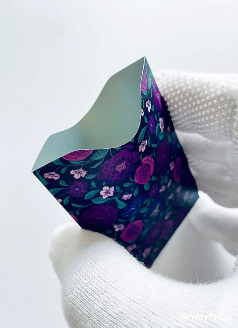 8 RFID Blocking Sleeves With Purple Designs, floral anti theft card protector held in hand, sturdy card sized for wallets.