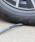 Heavy Hitter Air Compressor Hose Three Eighth By Fifty Feet Hybrid Line visible beneath a tire on a concrete surface.