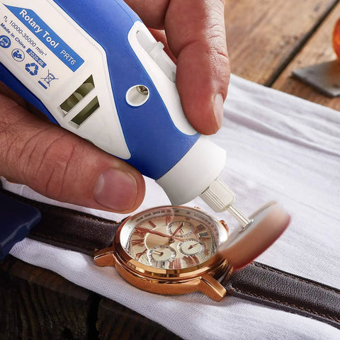 Hand using rotary tool from 357 Piece Rotary Tool Accessories Kit with One Eighth Inch Shanks to polish a watch face.