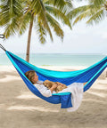 Woman relaxing with dog in Blue Outdoor Camping Hammock Portable With Tree Straps And Rope, 56 By 103 Inches, beach view