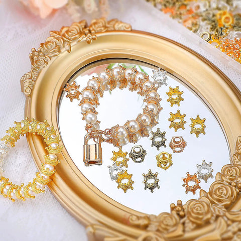 200 Piece Mini Crown Charms For Jewelry Making Colorful Gold And Silver Mixed Metals displayed on decorative frame mirror