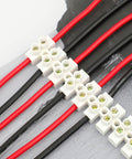 7 Piece 12 Position Dual Row Terminal Block Set for Electrical Wiring 10A 380V Barrier Strip Connector in use with red and black wires