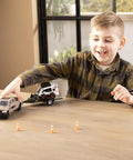 Child playing with One Thirty Two Scale Die Cast Skid Steer And Pickup Truck Construction Toy Set With Trailer And Cones Plus Worker Figure