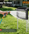 Cordless Outdoor Solar Bug Zapper With 4500V Grid Waterproof Mosquito Killer being cleaned with a hose in a yard setup