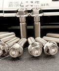 Titanium M6 Flanged Hex Bolts Set, 1.0mm Pitch, Ti 6Al 4V Grade 5 Alloy positioned in front of a model car.