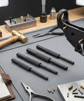 Roll Pin Starter Punch Set For AR Builds Four Starter Punches In Sizes One Sixteenth Five Sixty Fourths Three Thirty Second And One Eighth Inches Heat Treated Steel With Black Finish Keeps Pins In Place During Installation on gunsmithing workbench