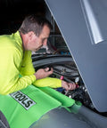 Mechanic using Universal Cooling System Adapter Kit for Radiator Pressure Testing on car engine, fits plastic reservoirs.