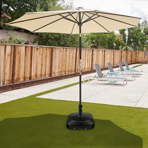 Heavy Duty 100Lb Umbrella Base With Four Locking Wheels in a patio setting, supporting a large beige umbrella on grass