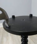 Installing 16 Pack Self Leveling Table Glides With Quarter Inch Threaded Stem on a round black table using a hammer