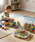 Child playing with building blocks stored in Three Pack Clear Hard Plastic Zipper Case Waterproof Cosmetic Bag Transparent Stackable Storage Organizer Box For Travel Toiletries And Makeup, Great For Toys, Art Supplies, Craft Kits, Hobby Storage And Small Gear, visible in a room.