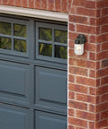 Level Up Your Porch With This Classic Jelly Jar Outdoor Wall Light In Sleek Matte Black on brick wall by garage.