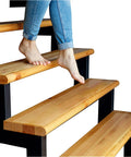 Bare feet on wooden stairs, showcasing Clear Non Slip Carpet Stair Treads For Wooden Steps 15 Pack 30 By 8 Inches Peel And Stick Slip Resistant Mats Indoor Outdoor Safe Traction For Stairs And Runners.