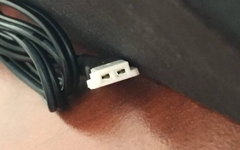 Close-up of Dual Pack USB Charging Cable Replacement For DX5 Drone Plug And Play Charger Cord connector on wooden surface.