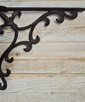 Heavy Duty Cast Iron Shelf Bracket Set With Ornate Fleur De Lis Pattern 10 By 10 Inch Shelf Supports For Sturdy Wall Shelves Classic Decorative Metal Brackets In Satin Brown Finish 8 Count shown against wood backdrop