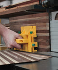 GRR-RIPPER 3D Pushblock With One Eighth Inch Leg guiding wood through table saw, durable yellow accessory enhancing safety and precision.