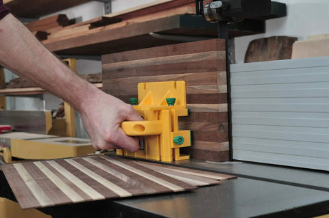 GRR-RIPPER 3D Pushblock With One Eighth Inch Leg guiding wood through table saw, durable yellow accessory enhancing safety and precision.