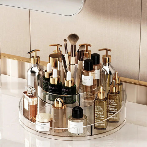 Real Deal Slick Spin 360 Round Rotating Makeup Organizer Clear Acrylic Lazy Susan displaying skincare, perfumes, and brushes on vanity.