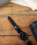 Slip On Wrist Compass For Survival Gear And Outdoor Adventurers, Easy Read Back Up Nav Tool on black watch band on wood surface