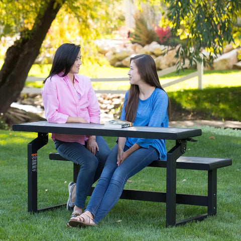 Two people sitting and talking at Outdoor Convertible Bench To Table In Seconds 55 Inch Harbor Gray Weather Resistant Polystyrene Slats.