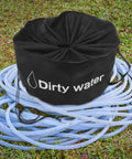 RV Hose And Water Tube Storage Bag Big Capacity Organizer with "Dirty Water" print, lying on coiled blue hoses on grass.