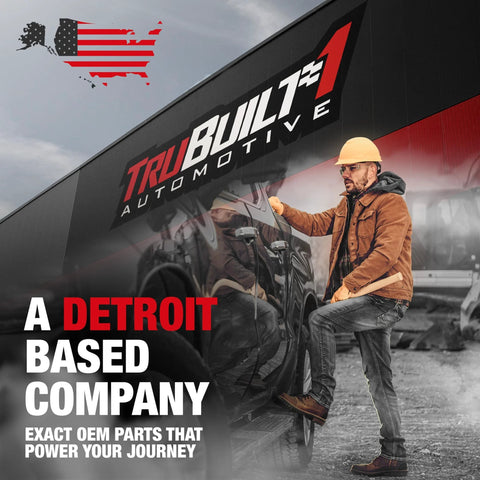 Man in hard hat standing by TruBuilt Automotive building with Detroit-based company sign.