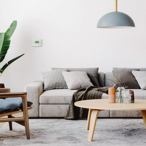 Living room featuring Smart 5-1-1 Day Programmable Thermostat With Early Start on wall, modern decor, and cozy furnishings.