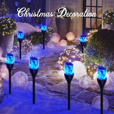 Solar Outdoor Lights 6 Pack Tiki Torches With Flickering Flame illuminating a snowy garden path with blue light decorations