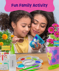 Mother and child painting pots from Paint And Plant Stoneware Flower Garden Kit For Kids 6 To 12 with marigold and zinnia flowers displayed