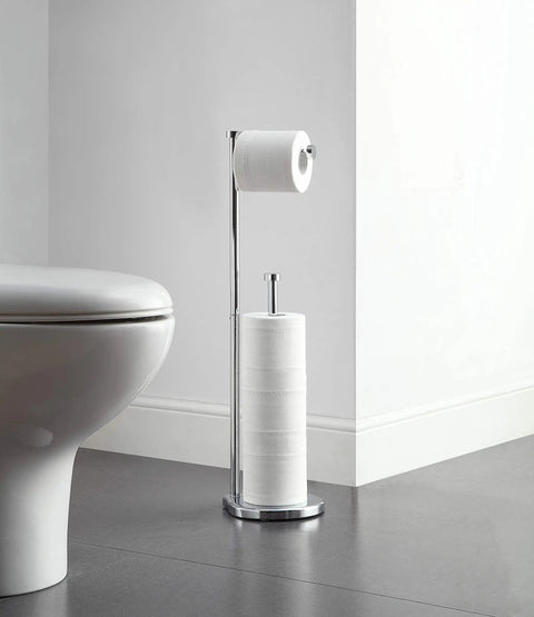 Free Standing Toilet Paper Holder With Reserve Space For Jumbo Rolls, Chrome Finish, next to toilet in minimalistic bathroom.